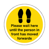 Please Wait Until Person In Front Has Moved Floor Sticker - Yellow | Safety-Label.co.uk